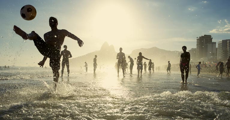Footballers playing on the beach